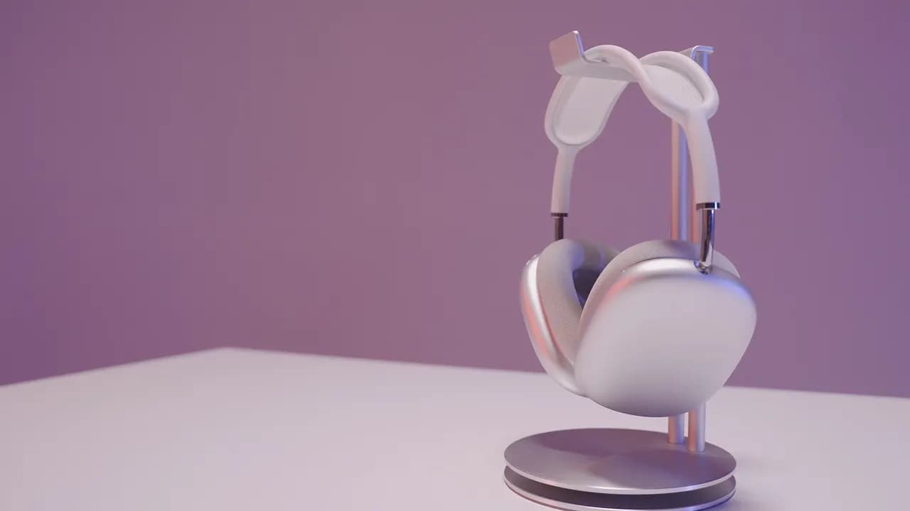 White over-ear wireless headphones on a stand on a white table